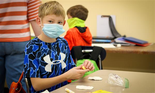 Boy works on food model made with clay
